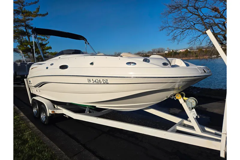 Slide: The Image of 2005 Chaparral Sunesta 232 boat on trailer by a lake, under clear blue sky. - 8