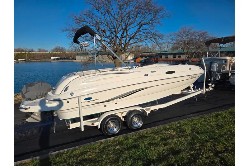 Slide: The Image of 2005 Chaparral Sunesta 232 boat on trailer by a lakeside, under clear blue sky. - 9