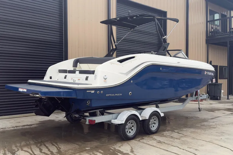 The Image of 2022 Bayliner DX 2250 boat on trailer, blue and white exterior, parked outside. - 0