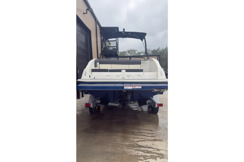 Slide: The Image of 2022 Bayliner DX 2250 boat rear view in a storage facility. - 14
