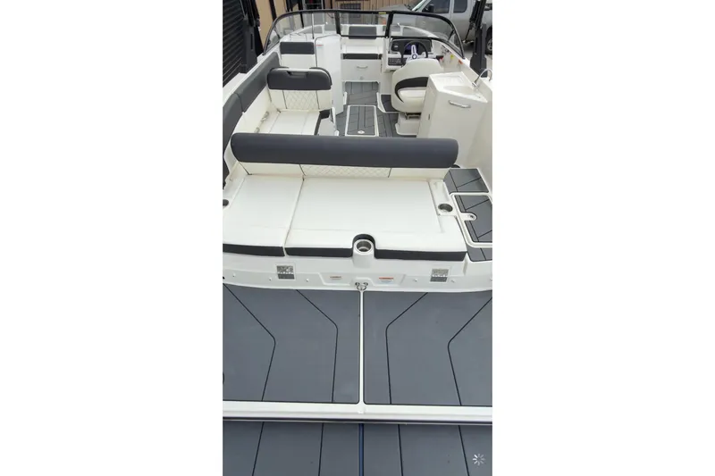 Slide: The Image of 2022 Bayliner DX 2250 boat interior with seating and helm, showcasing modern design. - 2