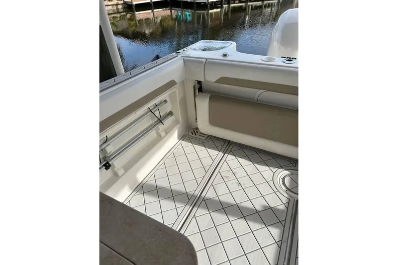 Slide: The Image of Interior view of 2016 Sailfish 275 DC boat, featuring cushioned seating and patterned flooring. - 11