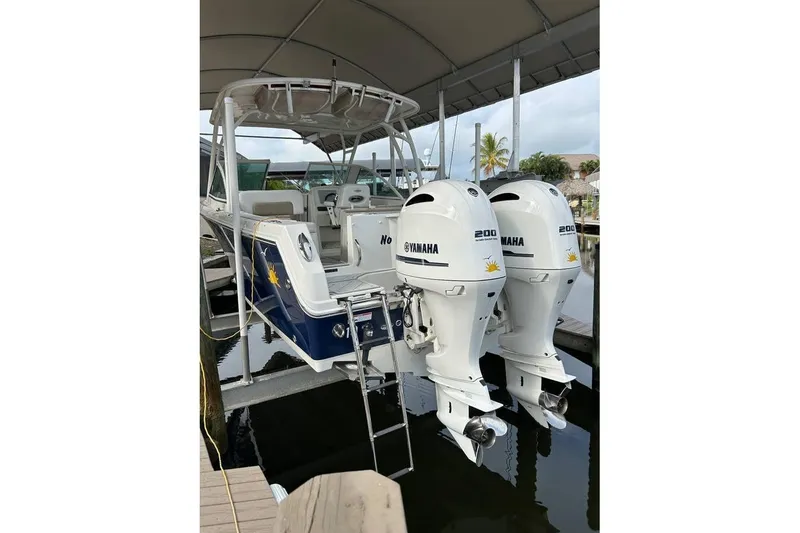 Slide: The Image of 2016 Sailfish 275 DC boat with twin Yamaha 200 engines docked under a canopy. - 17
