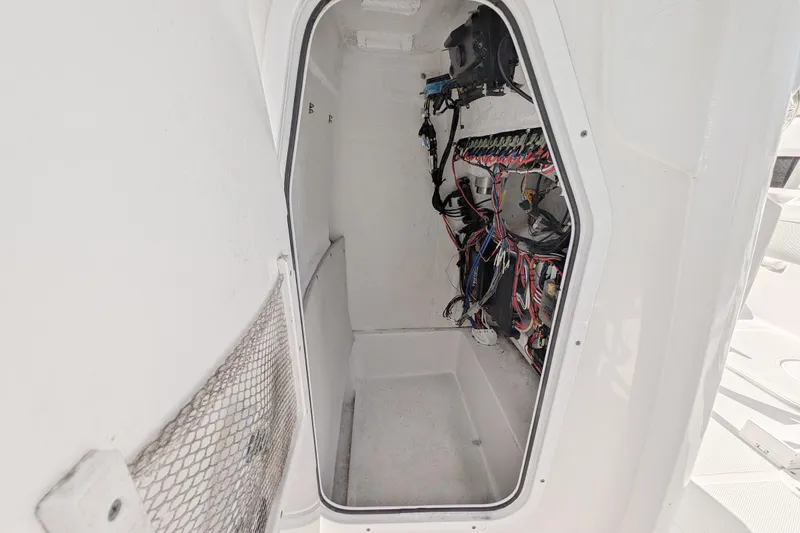Slide: The Image of 2021 Sea Hunt BX 22 BR boat compartment with wiring and storage space. - 14