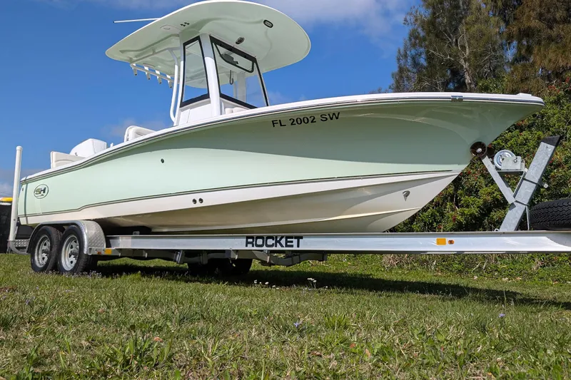 Slide: The Image of 2021 Sea Hunt BX 22 BR boat on trailer, parked on grass under blue sky. - 2