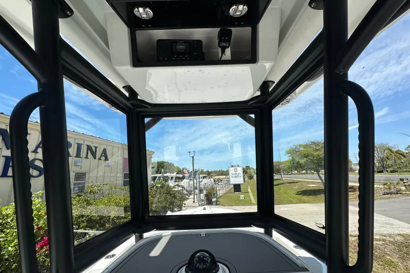 Slide: The Image of Interior view from a 2026 Caymas 26 HB boat, showcasing marina and clear skies. - 10