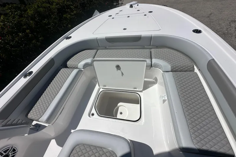 Slide: The Image of 2026 Caymas 26 HB boat interior with cushioned seating and storage compartment. - 14