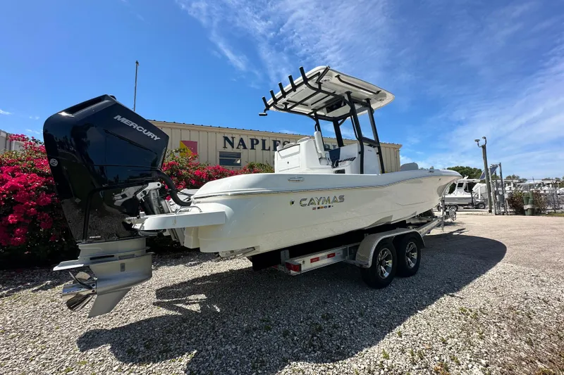 Slide: The Image of 2026 Caymas 26 HB boat with Mercury engine on trailer, parked outdoors. - 4