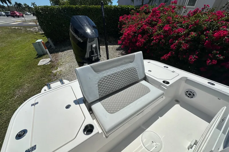 Slide: The Image of 2026 Caymas 26 HB boat with Mercury engine, featuring a cushioned seat and floral backdrop. - 6