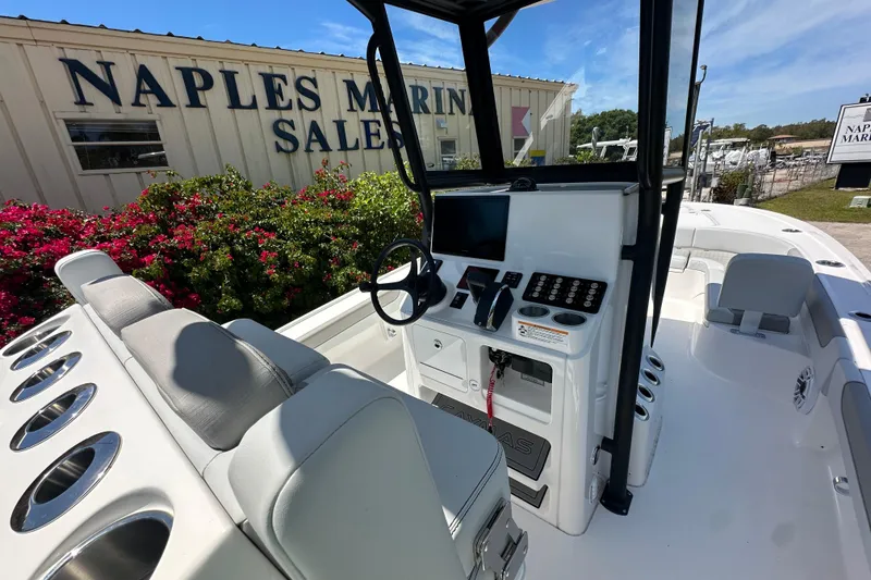 Slide: The Image of 2026 Caymas 26 HB boat interior at Naples Marine Sales, featuring modern controls and seating. - 7
