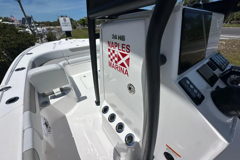 Slide: The Image of 2026 Caymas 26 HB boat at Naples Marina, featuring sleek white interior and control panel. - 8
