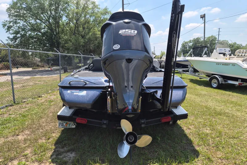 Slide: The Image of 2021 Skeeter ZXR20 boat with powerful outboard motor, parked on grass. - 3