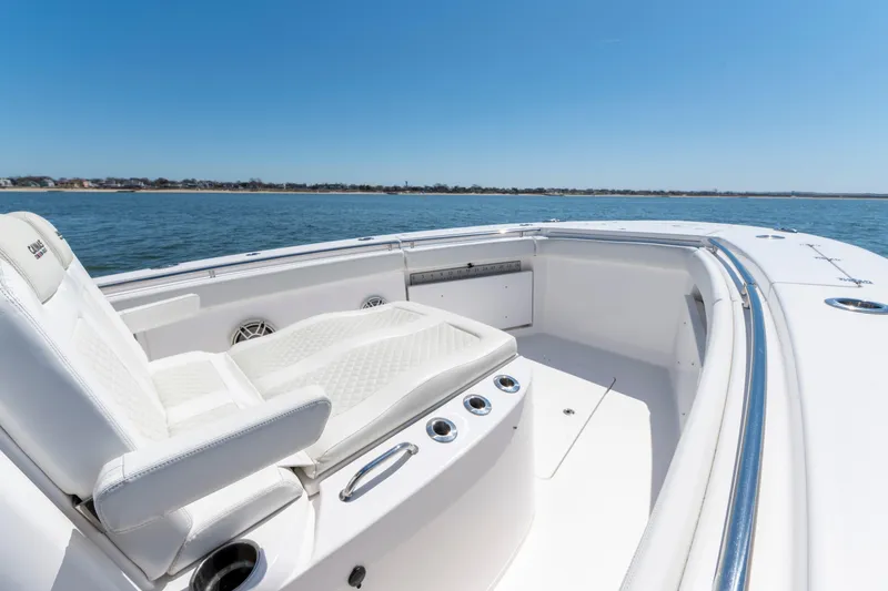 Slide: The Image of 2021 Caymas 341 CC boat interior with white seating, on calm water under clear blue sky. - 15