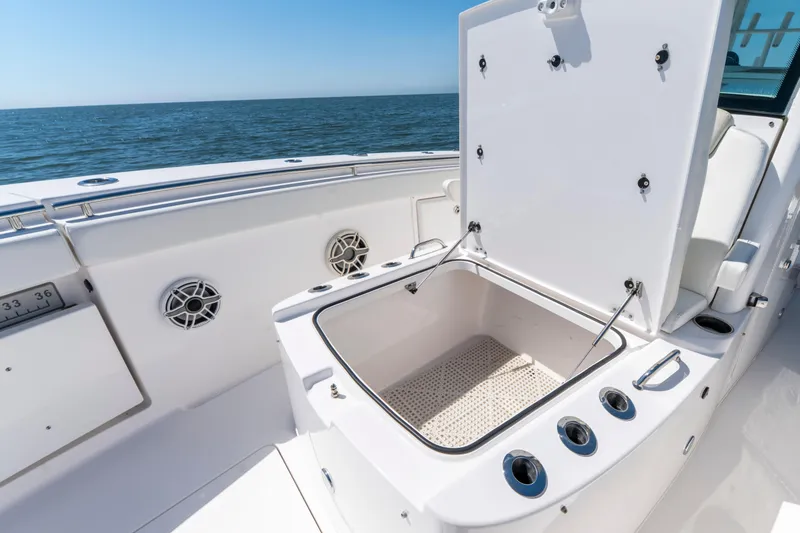 Slide: The Image of 2021 Caymas 341 CC boat with open storage compartment, ocean view in background. - 18