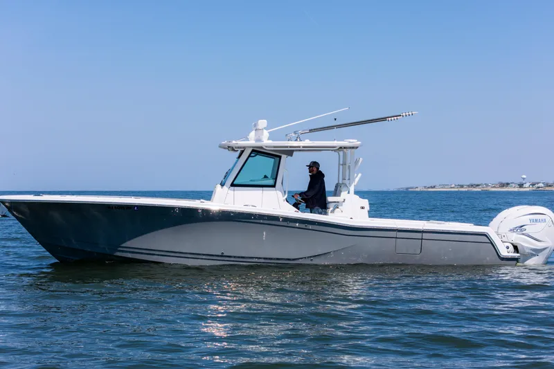 Slide: The Image of 2021 Caymas 341 CC boat cruising on open water under clear blue sky. - 2