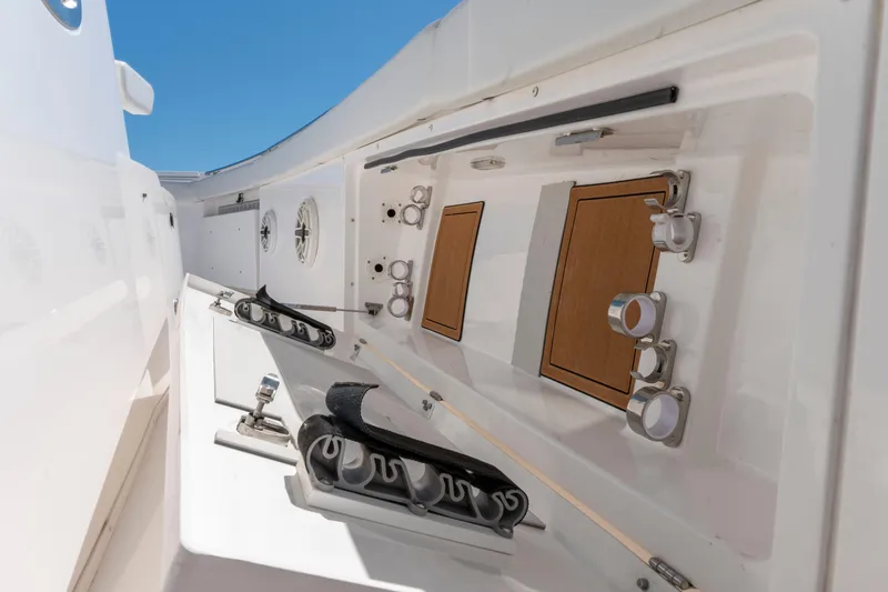 Slide: The Image of 2021 Caymas 341 CC boat interior with rod holders and storage compartments. - 21