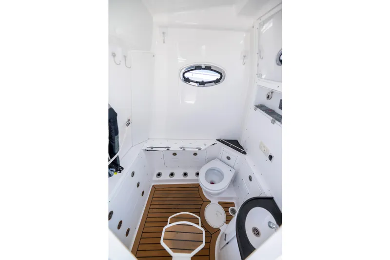Slide: The Image of 2021 Caymas 341 CC boat interior bathroom with wooden flooring and porthole window. - 24