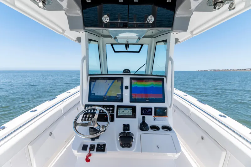 Slide: The Image of 2021 Caymas 341 CC boat helm with advanced navigation displays on open water. - 6