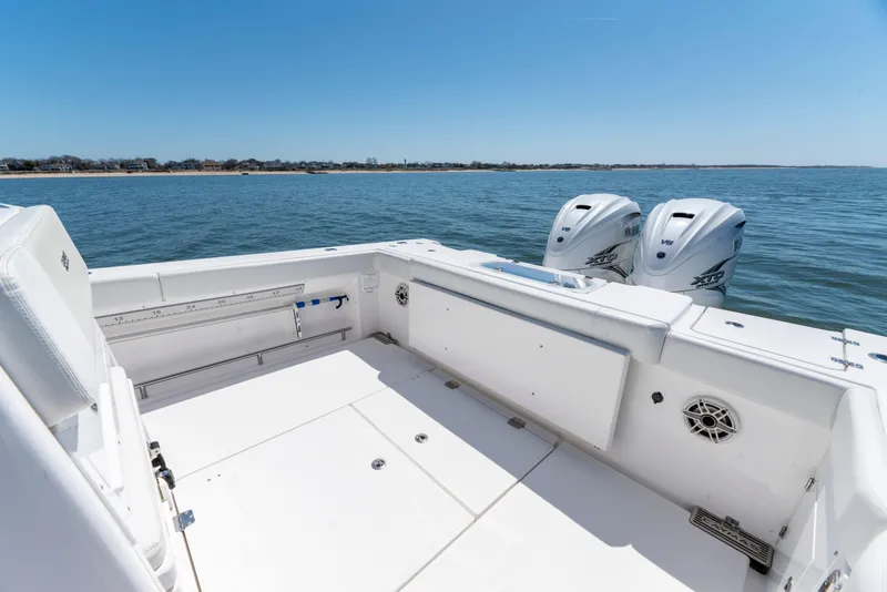 Slide: The Image of 2021 Caymas 341 CC boat deck with twin outboard engines on open water. - 7