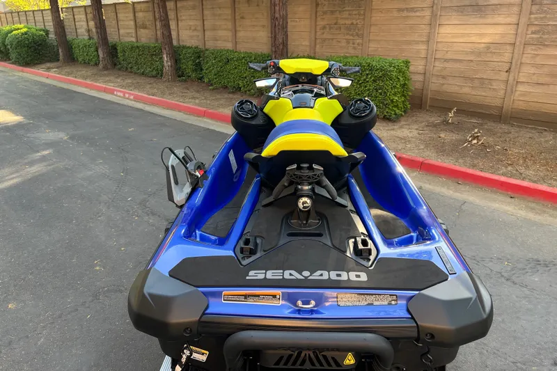 Slide: The Image of 2021 Sea-Doo Wake 170 jet ski, blue and yellow, parked on a street. - 7