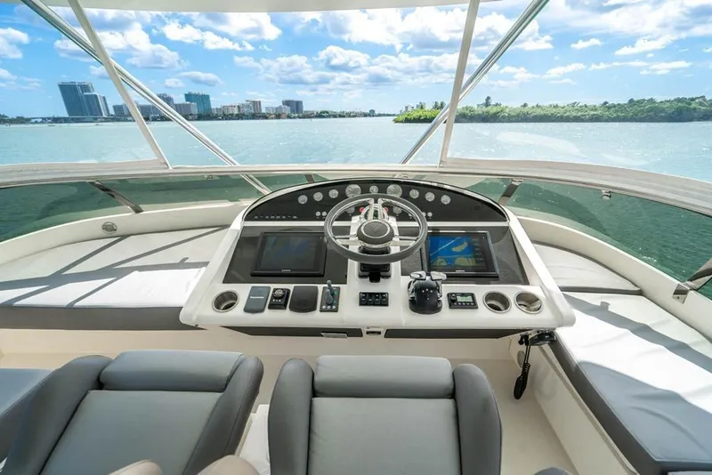 Slide: The Image of Cockpit view of 2020 Fairline 68 yacht with modern navigation equipment and city skyline. - 11