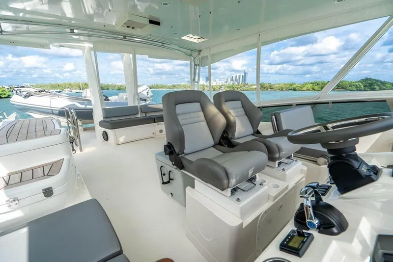 Slide: The Image of Luxurious 2020 Fairline 68 yacht interior with modern helm and seating, overlooking scenic waters. - 13