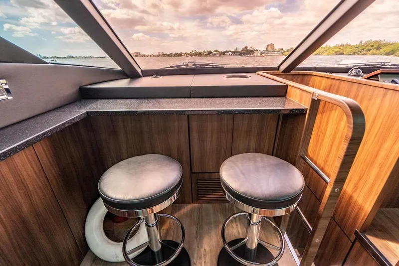 Slide: The Image of Interior of 2020 Fairline 68 yacht with modern bar stools and panoramic window view. - 31