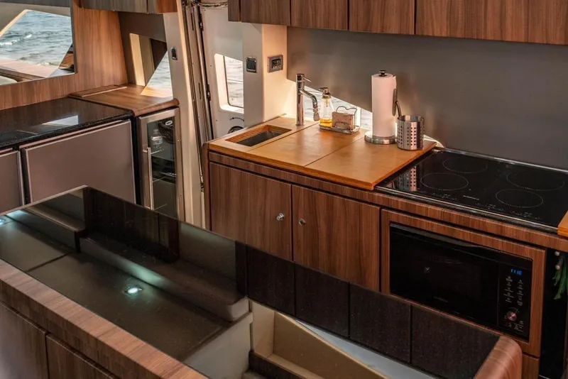 Slide: The Image of Modern kitchen interior on 2020 Fairline 68 yacht, featuring sleek wood cabinetry and appliances. - 34