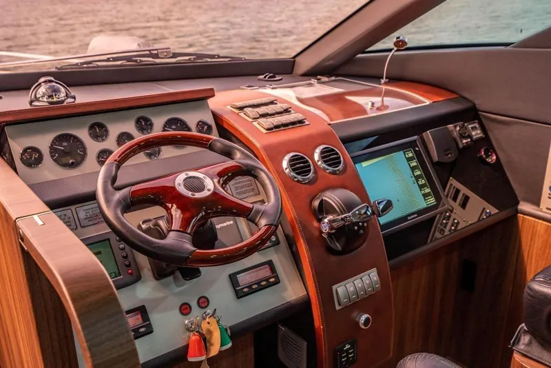 Slide: The Image of Cockpit of 2020 Fairline 68 yacht with wooden steering wheel and modern controls. - 38
