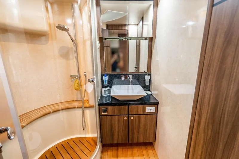 Slide: The Image of Luxurious bathroom on a 2020 Fairline 68 yacht with modern fixtures and wooden accents. - 46