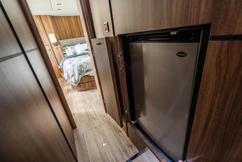Slide: The Image of Interior of 2020 Fairline 68 yacht with wood paneling and compact refrigerator. - 51
