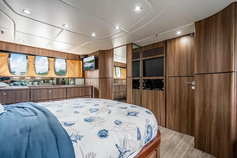 Slide: The Image of Luxurious Fairline 68 yacht bedroom interior, featuring elegant wood paneling and modern design, 2020 model. - 53