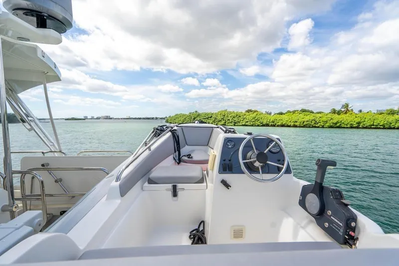 Slide: The Image of Cockpit view of 2020 Fairline 68 yacht on serene water with lush greenery. - 8