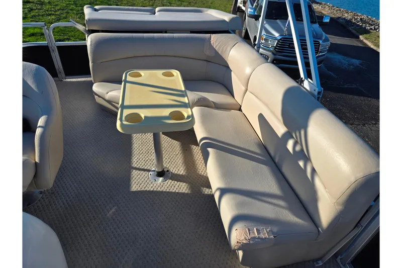 Slide: The Image of 2005 Lowe Trinidad 220 boat interior with beige seating and a central table. - 13