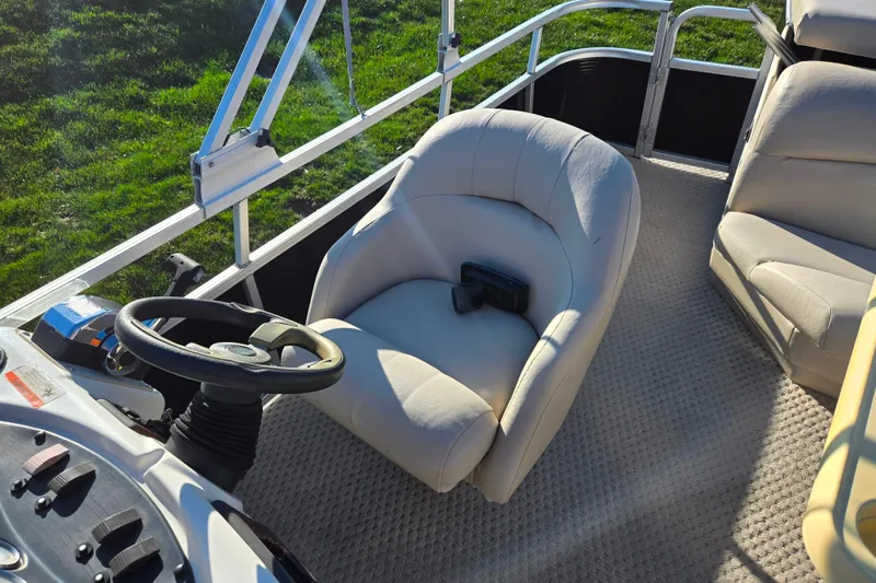 Slide: The Image of 2005 Lowe Trinidad 220 boat interior with steering wheel and plush seating. - 14