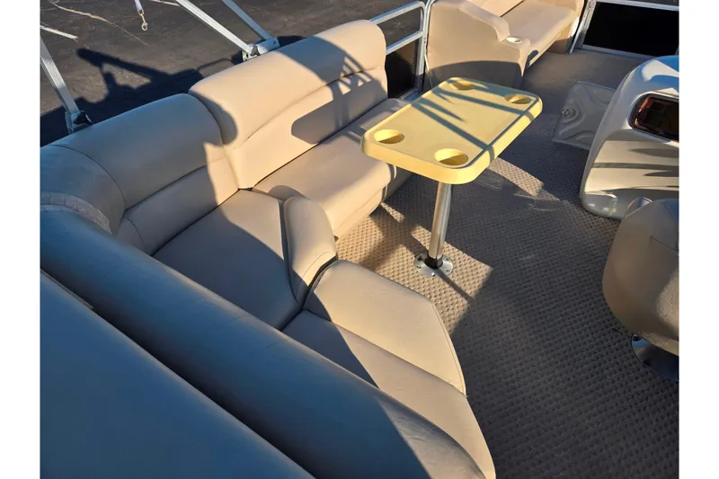 Slide: The Image of 2005 Lowe Trinidad 220 boat interior with beige seating and a yellow table. - 18
