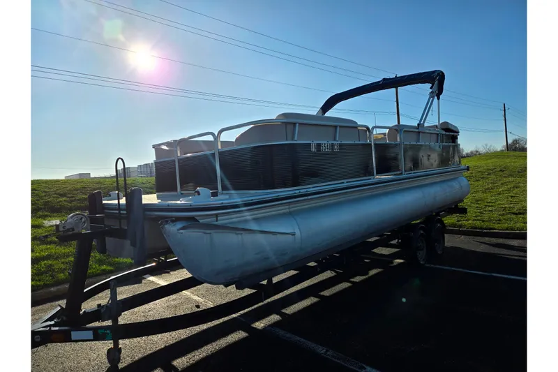 Slide: The Image of 2005 Lowe Trinidad 220 pontoon boat on trailer under bright sun. - 5