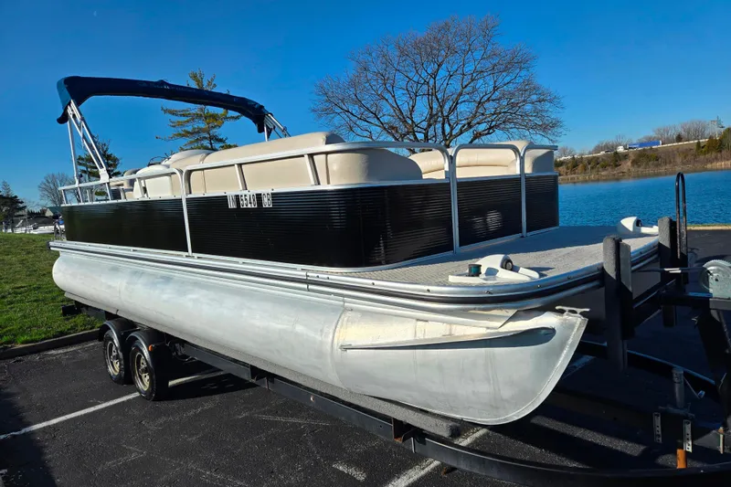 Slide: The Image of 2005 Lowe Trinidad 220 pontoon boat on trailer by a lake. - 8