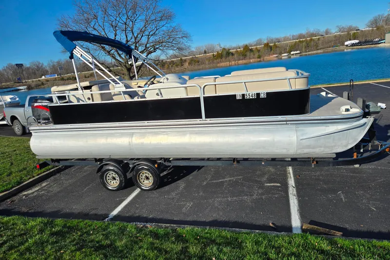 Slide: The Image of 2005 Lowe Trinidad 220 pontoon boat on trailer by a lake. - 9