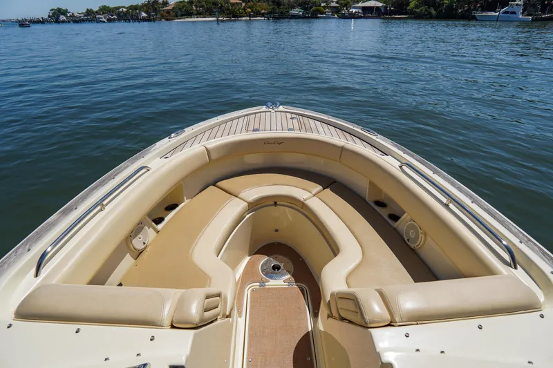 Slide: The Image of 2017 Chris-Craft Calypso 26 boat interior with beige seating on calm water. - 10