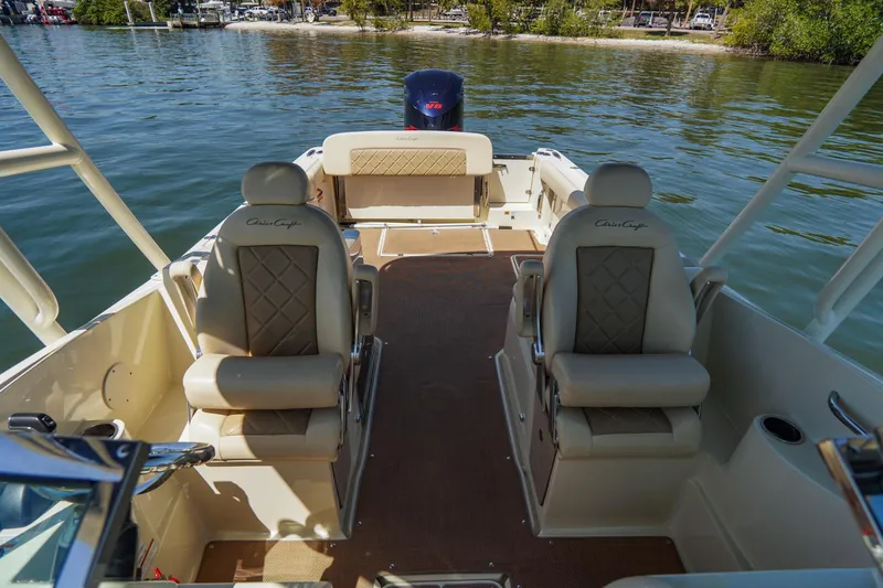 Slide: The Image of 2017 Chris-Craft Calypso 26 boat interior with luxurious seating on calm water. - 15