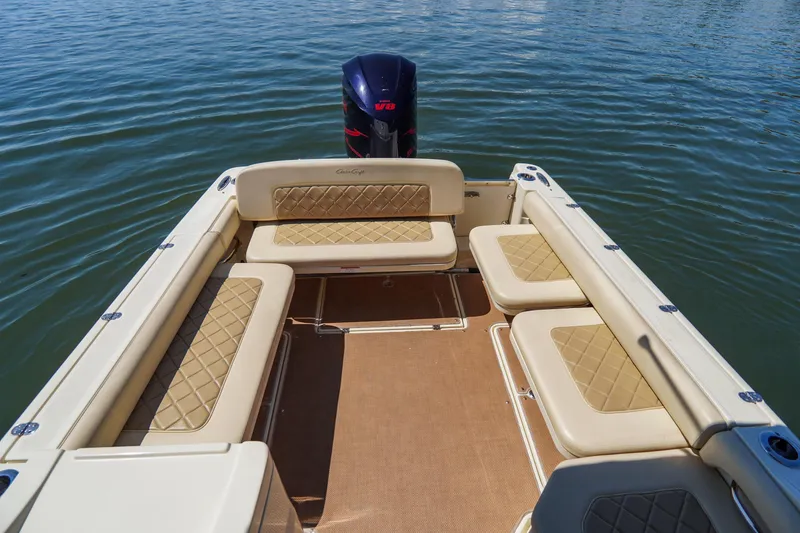 Slide: The Image of 2017 Chris-Craft Calypso 26 boat interior with beige seating and V8 engine on water. - 26