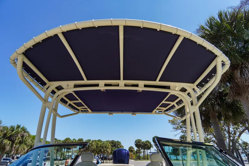 Slide: The Image of 2017 Chris-Craft Calypso 26 boat canopy with blue cover, palm trees in background. - 30