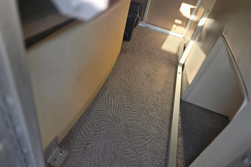 Slide: The Image of Interior view of a 2008 Bennington 2275RL boat, featuring carpeted flooring and sunlight. - 19