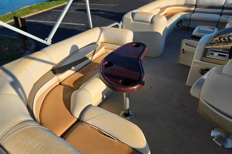 Slide: The Image of 2008 Bennington 2275RL boat interior with beige seating and a wooden table. - 21
