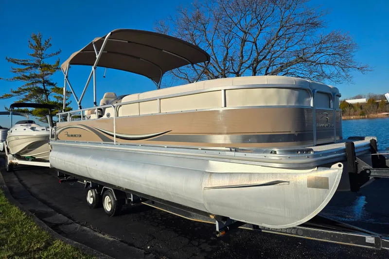 Slide: The Image of 2008 Bennington 2275RL pontoon boat on trailer by a lake, under clear blue sky. - 8