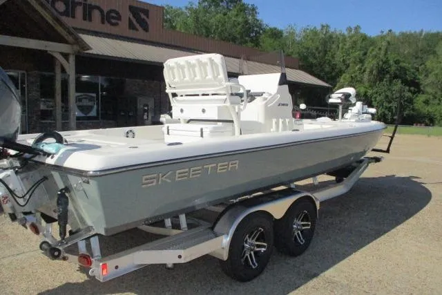 Slide: The Image of 2025 Skeeter SX241 boat on trailer, parked outside a marine shop. - 11
