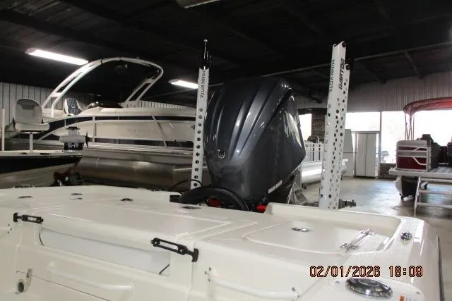 Slide: The Image of 2025 Skeeter SX241 boat in showroom with outboard motor, surrounded by other boats. - 6