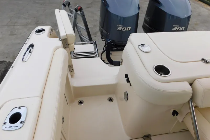 Slide: The Image of 2015 Grady-White Freedom 307 boat interior with Yamaha 300 engines, featuring seating and cup holders. - 11