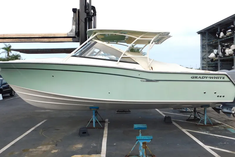 Slide: The Image of 2016 Grady-White Freedom 307 boat on stands in a marina setting. - 2